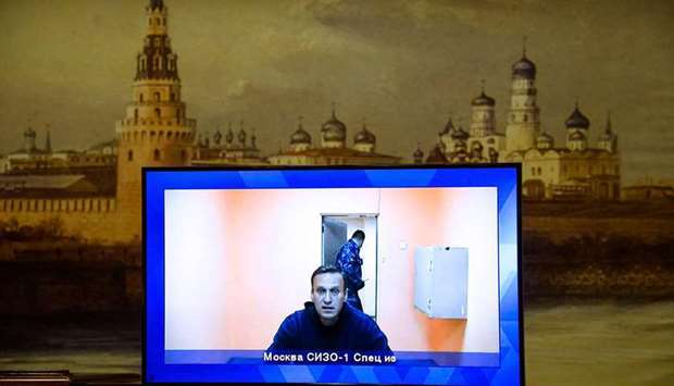Alexei Navalny appears on a screen set up at a hall of the Moscow Regional Court via a video link