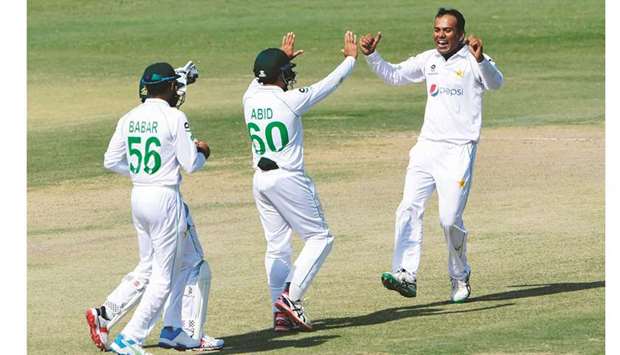 Pakistanu2019s Nauman Ali (R) celebrates with teammates after taking the wicket of South Africau2019s Anrich Nortje (not pictured) during the fourth day of the first Test match at the National Stadium in Karachi yesterday.