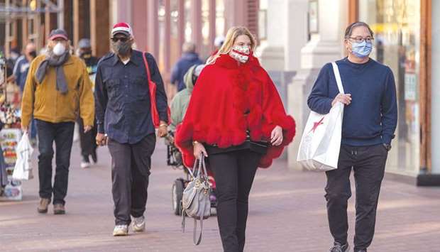 Pedestrians carry shopping bags in San Francisco. Consumer spending in the US slipped 0.2% last month as outlays at restaurants declined, a report from the Commerce Department said yesterday.