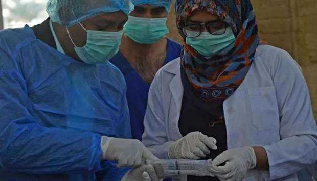 A doctor (L) and a paramedic attend a training session for the upcoming coronavirus vaccination drive in Karachi. AFP