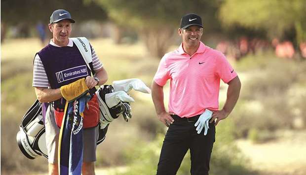 Paul Casey and his caddie after he had chipped in for a birdie on the 17th hole during the third round of the Omega Dubai Desert Classic at Emirates Golf Club in Dubai yesterday. (Getty Images)