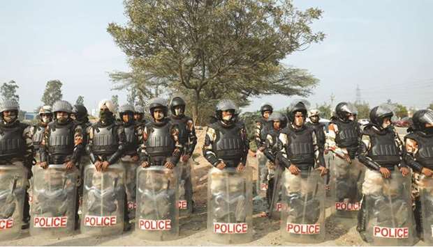 Police officers in riot gear stand guard at the site of a protest against the farm laws at the Singhu border in New Delhi yesterday.