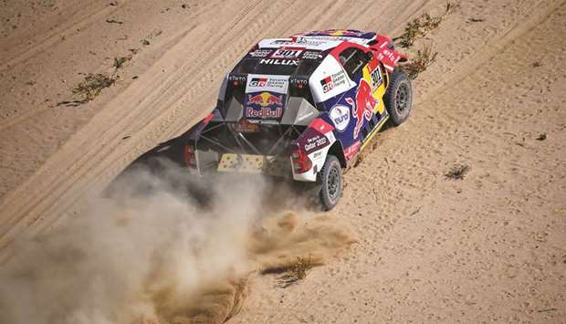 Toyotau2019s Qatari driver Nasser al-Attiyah and his co-driver Mathieu Baumel of France compete during Stage 1 of the 2021 Dakar Rally between Jeddah and Bisha in Saudi Arabia yesterday. (AFP)