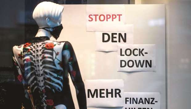 A dummy wearing a skeleton-designed shirt stands next to posters reading u2018stop the lockdown u2013 more financial aidu2019 at a shop in the pedestrian area in Cologne, western Germany.