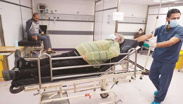 A nurse pushes a bed on which rests a Covid-19 patient at Rafic Hariri University Hospital Corona ER in Beirut yesterday.