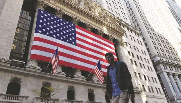 A person walks past the New York Stock Exchange at the Wall Street in New York City (file). The New York Stock Exchange said on Wednesday it will delist three Chinese telecom companies from January 11, in another U-turn a day after US Treasury Secretary Steve Mnuchin told the NYSE chief he disagreed with its earlier decision to reverse the delistings.