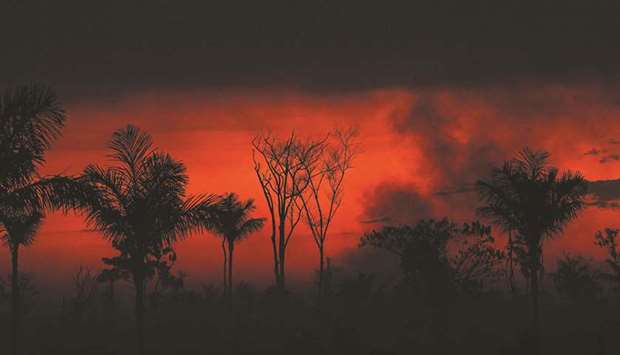 In this file photo taken on August 11, 2020 smoke rises from an illegal fire in Amazon rainforest reserve, north of Sinop in Mato Grosso State, Brazil. Moodyu2019s Investors Service says 18 sectors have a combined $7.2tn of debt with u201chigh inherent exposure to physical climate risks,u201d such as devastating wildfires, storms and other calamities. To put that number in perspective, only two countries have a gross domestic product thatu2019s larger: the US and China. Japan, the worldu2019s third-largest economy, has a GDP of about $5tn.