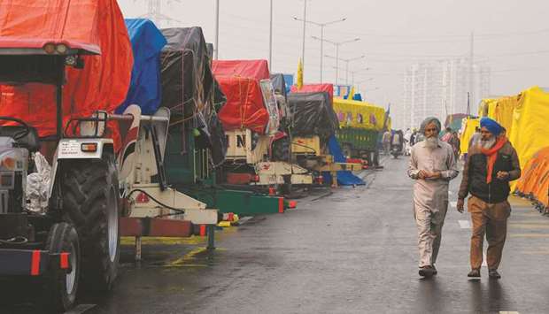 Protesting farmers walk past tents set on tractoru2019s trailers along a highway blocked by farmers protesting against the central governmentu2019s recent agricultural reforms, at the Delhi-Uttar Pradesh state border in Ghaziabad, yesterday.