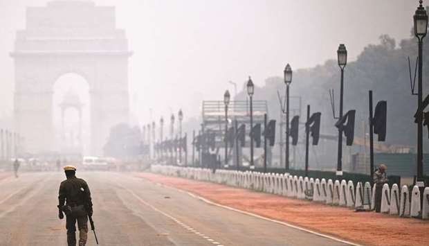 A policeman walks along the Rajpath street amid smoggy conditions in New Delhi on January 2. Indiau2019s economy is set for its biggest annual contraction in records going back to 1952 as the rapid spread of virus cases and measures to contain them hurt businesses and households.