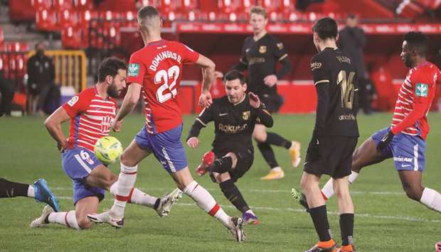 Barcelonau2019s Lionel Messi (centre) scores against Granada in the La Liga in Granada, Spain, yesterday. (Reuters)