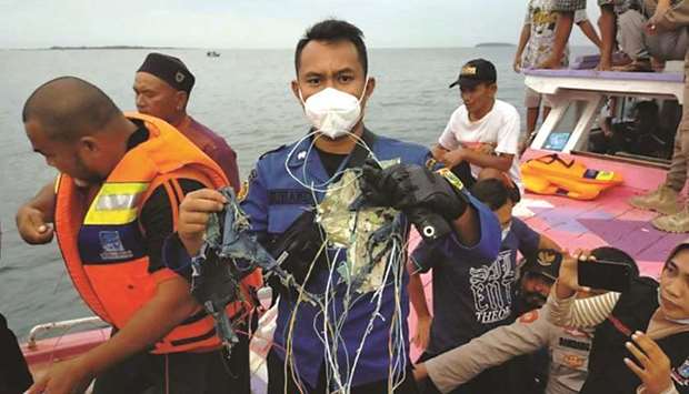 A member of the rescue team looking for an Indonesian plane that lost contact after taking off from the capital Jakarta holds suspected debris, at sea, yesterday.