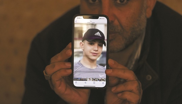 Muammar Nakhleh, the father of 17-year-old Palestinian prisoner Amal, shows a photograph of his son on his telephone, in Jalazun refugee camp, near the occupied West Bank city of Ramallah.