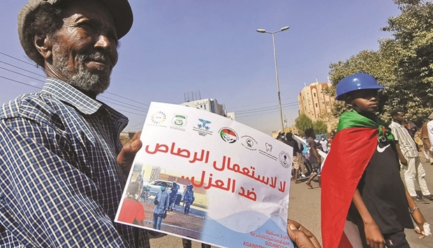 A Sudanese man holds a poster that reads in Arabic u201cNo to the use of live bullets against the unarmedu201d during a protest against the October 2021 military coup, in the capital Khartoum, yesterday.