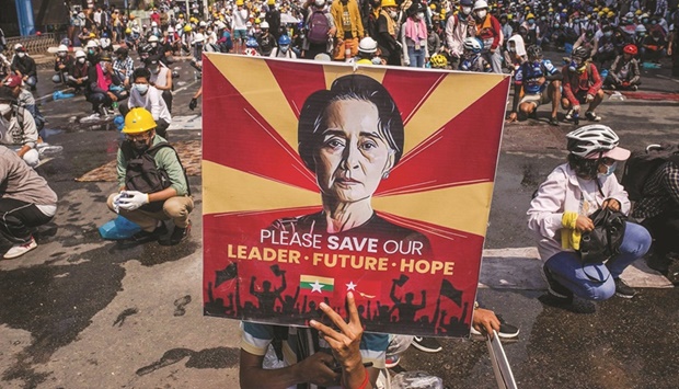 A protester holds a poster featuring Aung San Suu Kyi as they take part in a demonstration against the military coup in Yangon in this file picture.