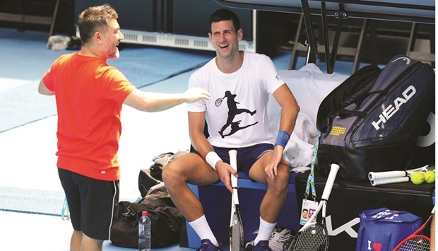 Serbiau2019s Novak Djokovic talks to his team member during a training session in Melbourne yesterday. (AFP)