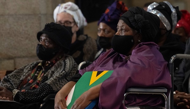 Leah Tutu (R), widow of South African anti-Apartheid icon Archbishop Desmond Tutu, holds the South African national flag during the requiem mass of Tutu at St. Georgeu2019s Cathedral in Cape Town on January 1, 2022.
