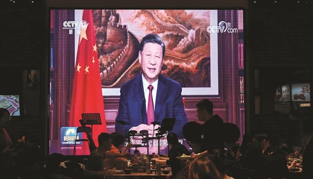 People listen to President Xi Jinpingu2019s speech at a restaurant in Beijing on New Yearu2019s Eve. (AFP)