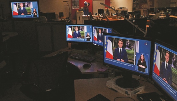 Images of French President Emmanuel Macron are seen on computer screens as he delivers his televised New Yearu2019s address to the nation from the Elysee Palace.