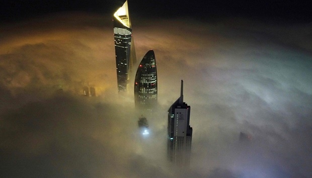 This aerial view shows Kuwait City's al-Hamra tower (L), the headquarters of The National Bank of Kuwait (C) and the al-Rayah tower (R), caught in heavy fog early on January 13, 2022.
