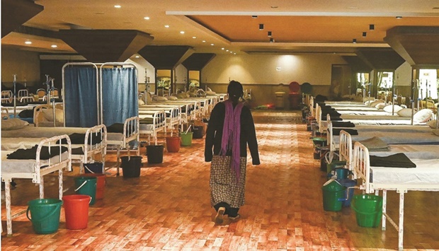 A patient walks inside a banquet hall temporarily converted into a Covid-19 care centre in New Delhi.