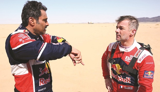 Toyotau2019s driver Nasser al-Attiyah of Qatar (left) speaks with French driver Sebastien Loeb during the Stage 11 of the Dakar Rally around Bisha in Saudi Arabia on Thursday. (AFP)