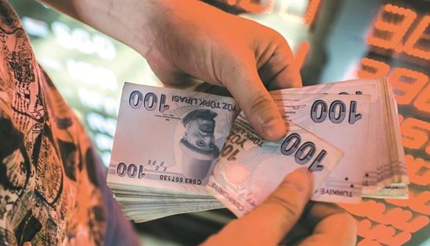 A money changer counts Turkish lira banknotes at a currency exchange office in Istanbul. The lira gained 0.3% to 13.58 to the dollar by 0925 GMT yesterday.