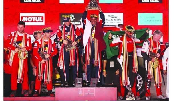 Toyota Gazoo Racing's Nasser al-Attiyah and co-driver Matthieu Baumel celebrate with the trophies on the podium after winning the Dakar Rally alongside runner-up Sebastien Loeb and co-driver Fabian Lurquin and third-placed Yazeed al-Rajhi and co-driver Michael Orr in Jeddah Friday. Reuters