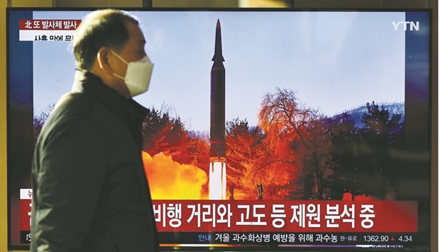 A man walks past a television report showing a news broadcast with file footage of a North Korean missile test, at a railway station in Seoul yesterday.