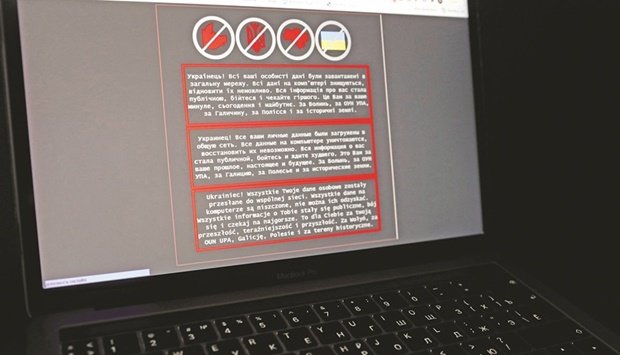 A laptop screen displays a warning message in Ukrainian, Russian and Polish, that appeared on the official website of the Ukrainian foreign ministry after a massive cyber-attack.