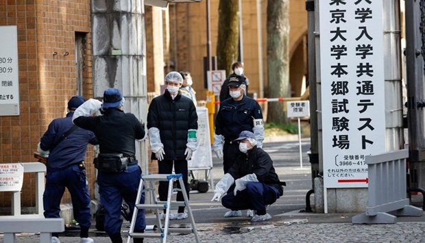 A police investigator speaks to another person at the site where a stabbing incident happened at an entrance gate of Tokyo University in Tokyo, Japan.