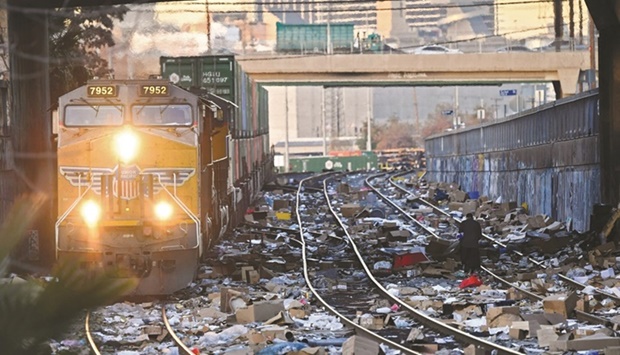 A Union Pacific locomotive passes through a section of train tracks littered with thousands of opened boxes and packages stolen from cargo shipping containers, in downtown Los Angeles.