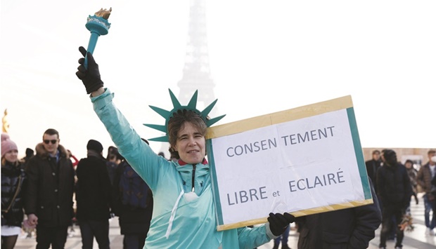 A woman holds a banner that reads u201cfree and informed consentu201d during a demonstration to protest against a bill that would transform Franceu2019s current Covid-19 health pass into a u201cvaccine passu201d on Trocadero plaza in Paris. (Reuters)