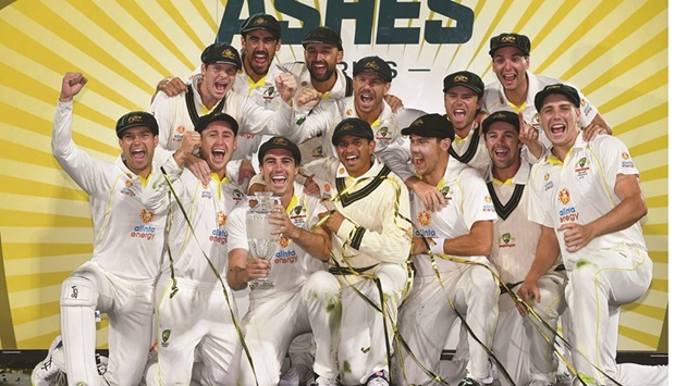 Australiau2019s players celebrate with the trophy after defeating England on the third day of the fifth Ashes Test in Hobart  yesterday. (AFP)