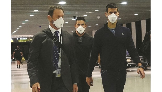 Novak Djokovic (right) walks in Melbourne airport before boarding a flight, after the Federal Court upheld a government decision to cancel his visa to play in the Australian Open in Melbourne yesterday. (Reuters)