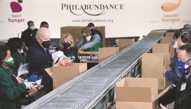 US President Biden and First Lady Jill Biden pack food boxes while volunteering in honour of Martin Luther King, Jr, Day of Service, at Philabundance, a hunger relief organisation, in Philadelphia.