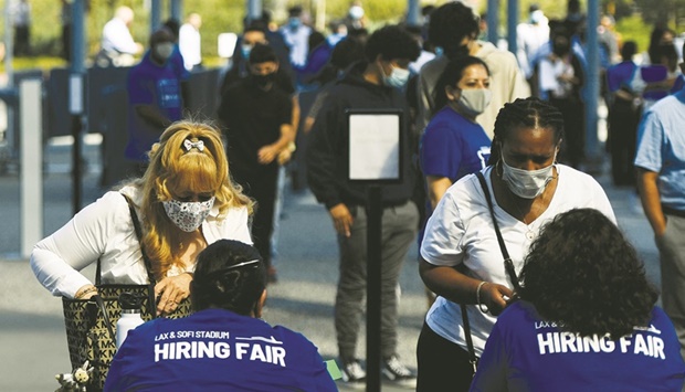 People receive information as they attend a job fair for employment with SoFi Stadium and Los Angeles International Airport employers, at SoFi Stadium in Inglewood, California (file). The ILO estimates the equivalent of around 52mn fewer jobs in 2022 versus pre-Covid levels, which amounts to about double its previous estimate from June 2021.
