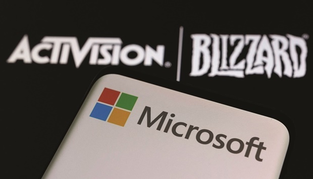 Microsoft logo is seen on a smartphone placed on displayed Activision Blizzard logo in this illustration taken yesterday. The deal announced by Microsoft on Tuesday, its biggest-ever and set to be the largest all-cash acquisition on record, will bolster its firepower in the booming videogaming market where it takes on leaders Tencent and Sony.