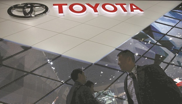 Visitors walk at Toyota Motor Corpu2019s booth at a motor show in Tokyo (file). The worldu2019s No 1 automaker is paring back production to 700,000 units in February, around 150,000 units lower than its original goal for the month, according to a statement on Tuesday.
