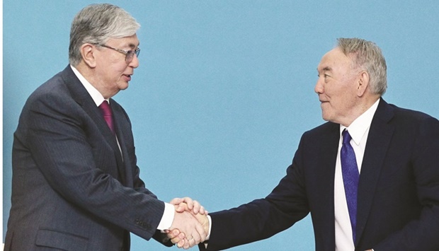 In this file photo taken on April 23, 2019, former Kazakh president Nursultan Nazarbayev (right) shakes hands with President Kassym-Jomart Tokayev during a congress of the ruling Nur Otan party in Nur-Sultan. (AFP)