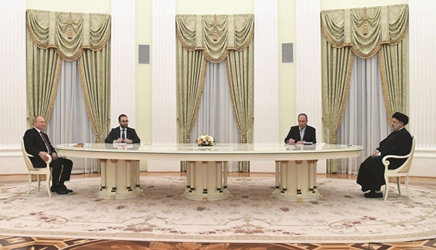 Russian President Vladimir Putin speaks with Iranian President Ebrahim Raisi during their meeting in Moscow, yesterday.