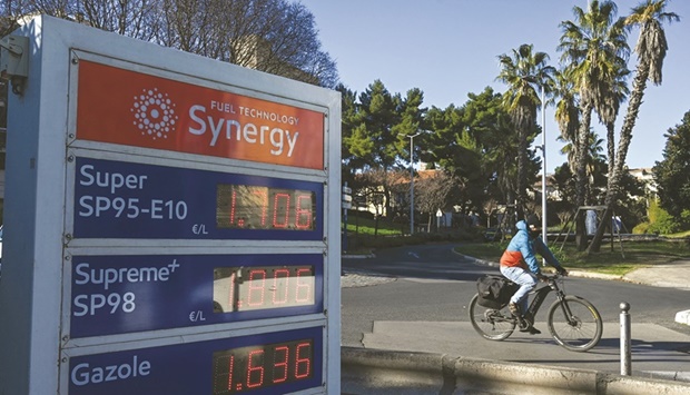 A cyclist passes by a gas station in Montpellier, southern France on January 18 as oil prices are at their highest since 2014. The IEA, which advises most major economies, raised projections for global oil demand by 200,000 barrels a day for both 2021 and 2022.