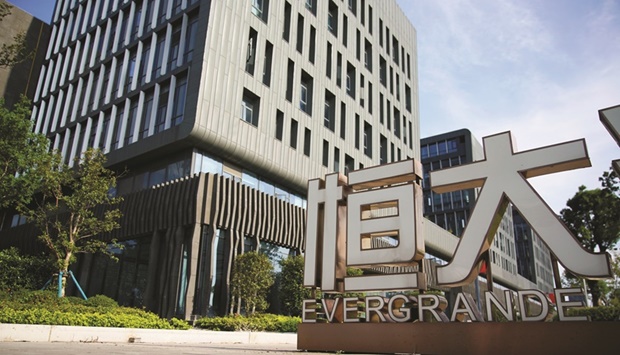 An Evergrande sign is seen at the Evergrande Automotive R&D Institute headquarters of China Evergrande Group in Shanghai. Regulatory curbs on borrowing have driven the sector into crisis, highlighted by China Evergrande Group which was once Chinau2019s top-selling developer but is now the worldu2019s most indebted property firm with liabilities of $300bn.