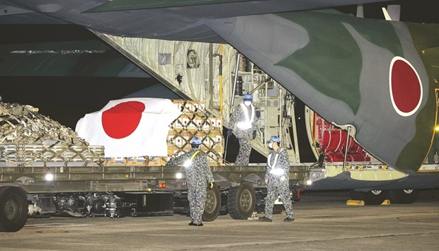 Japan Self-Defence Forces officers load relief supplies for a C-130 Hercules, to be deployed to Tonga with aid to help out the country devastated by a nearby eruption and tsunami, at Komaki air base in Komaki, Japan.