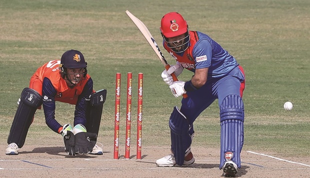 Afghanistanu2019s Rahmat Shah plays a shot as the Netherlandsu2019 wicketkeeper Scott Edwards watches during the first one-day international at the Asian Sports City Stadium in Doha. (AFP)