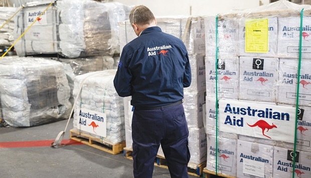 Department of Foreign Affairs and Trade Crisis Response Team Liaison Officer, Timothy Church, checks the pallets of humanitarian aid supplies embarked onboard HMAS Adelaide as the ship sails to support the nation of Tonga, yesterday.