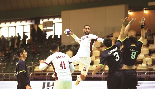 A Qatari player is poised to shoot against Uzbekistan during the Asian Handball Championships in Qatif, Saudi Arabia.