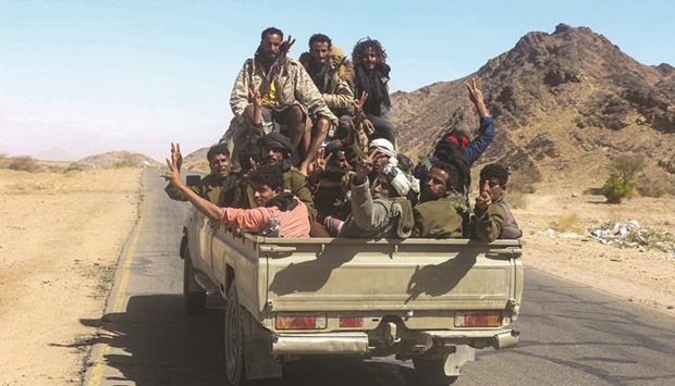 Yemeni pro-government fighters gather in the back of a pick up truck near the district of Harib, yesterday after Houthi rebels were expelled from the key battleground district by Giants Brigade fighters.