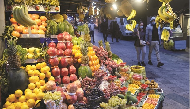 People wearing protective face masks walk at a local market in Istanbul (file). The exchange-rate volatility helped send inflation soaring to 36% in December, and most analysts expect it to approach 50% in coming months before easing to about 27% by year-end, according to a Reuters poll.
