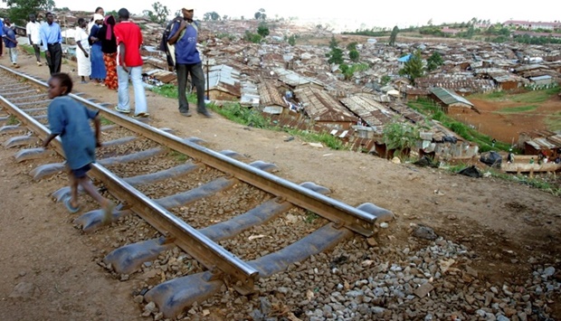 People walk along the uprooted Kenya-Uganda railway line in Nairobi's Kibera slums, April 15, 2009. REUTERS