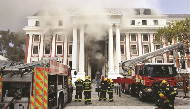 Firefighters work after a fire broke out in the Parliament in Cape Town yesterday.